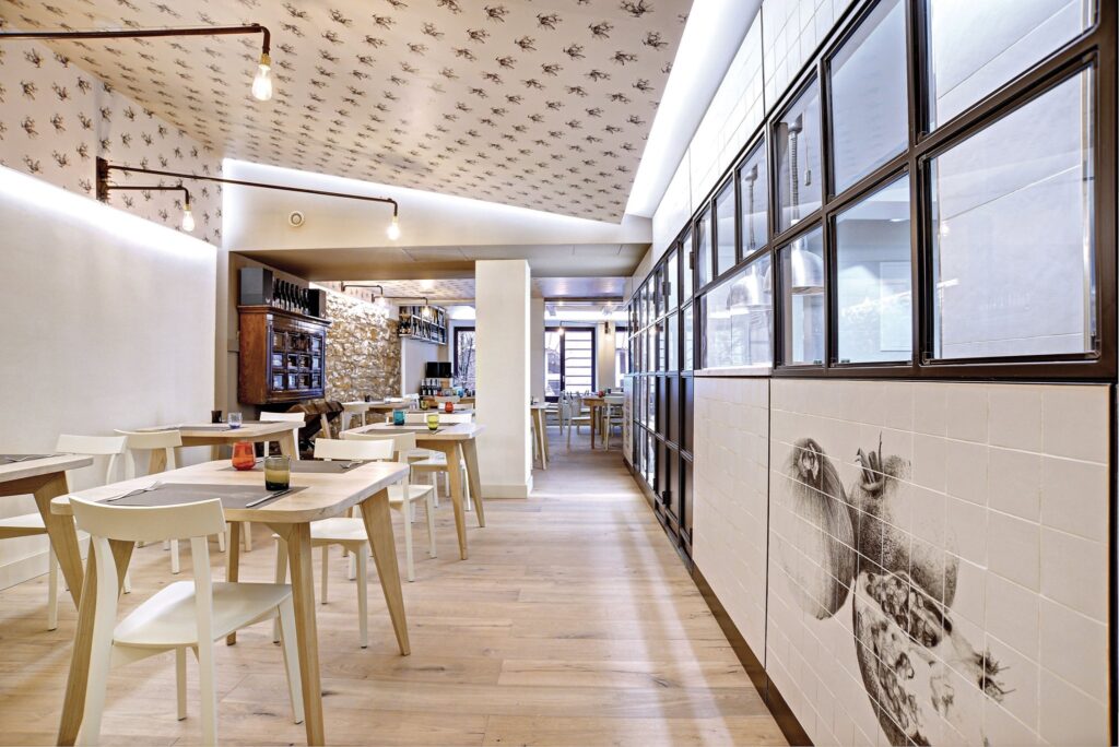 Interno di ristorante con soffitto in carta da parati stampata e parete decorata su misura.