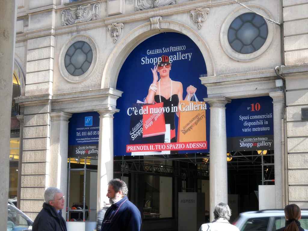 Telo pubblicitario di grande formato installato sulla facciata di un edificio storico nel centro di Torino.
